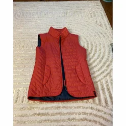 veste sans manche rose (elle parait rouge sur la photo mais elle est rose !)